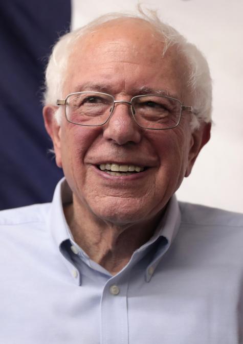 Image of U.S. Senator Bernie Sanders. An older white gentleman smiles warmily into the camera, he is wearing a light blue shirt and glasses